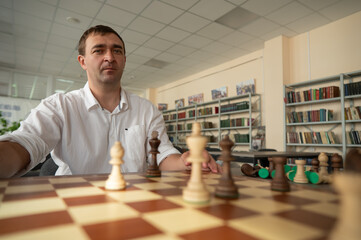 Middle aged Caucasian man playing chess. 