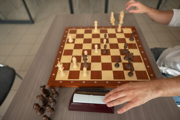Close up of hands of middle aged caucasian man playing chess. 