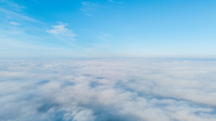 Aerial perspective showcasing fluffy white clouds floating under a clear blue sky, creating a serene natural atmosphere.