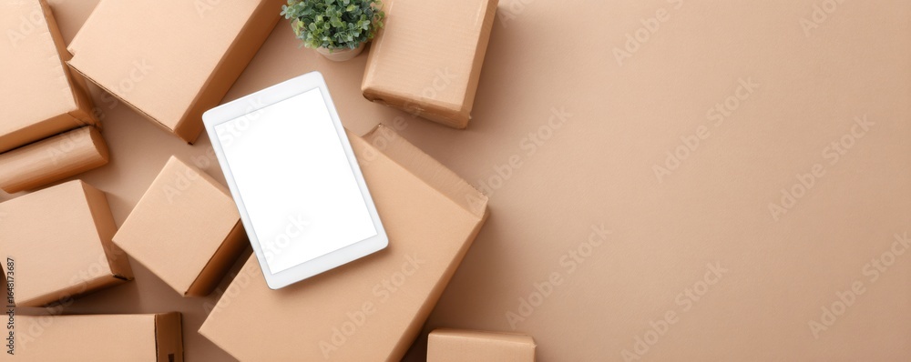 Poster Top view of multiple cardboard boxes for moving and shipping with a digital tablet on a beige background with copy space.