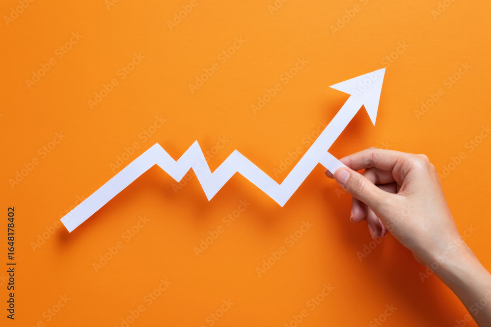 Poster visualizing growth a hand holds an upward arrow on an orange background symbolizing progress and pos