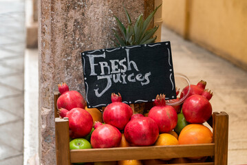 Fresh juices sign on top of crate with fresh fruits with 