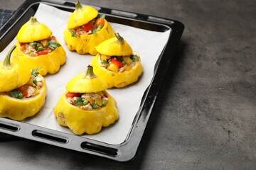 Tasty stuffed pattypan squashes on dark textured table, closeup