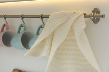 Clean waffle towel and cups hanging in kitchen, closeup