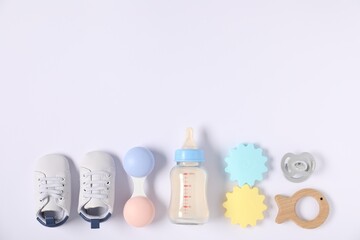 Feeding bottle with formula and baby accessories on light background, flat lay. Space for text