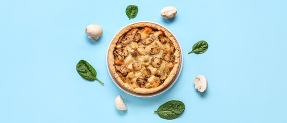 Mushroom pie with spinach leaves and champignons on blue background