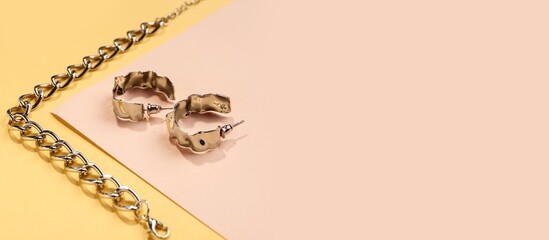 Beautiful silver bracelet and earrings on color background with space for text