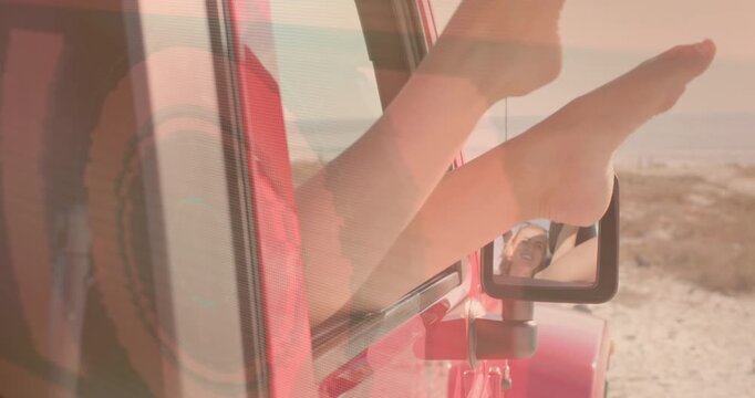 Passenger pausing red off-road vehicle for travel break, shifting bare feet on mirror for comfort