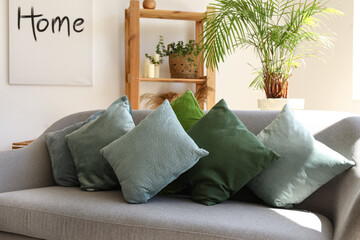 Stylish pillows on grey sofa in modern living room