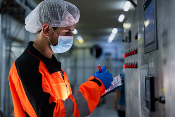 Workers in safety gear inside a factory are checking equipment and machinery to store chemicals and...