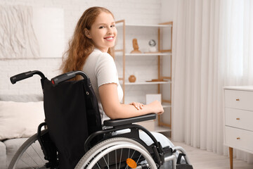 Smiling young redhead woman in wheelchair at home