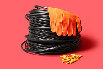 Wall plugs, fabric gloves and cables on red background