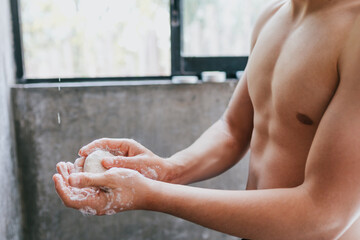 young hispanic man taking a shower and holding a soap in Mexico Latin America