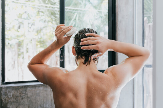 young hispanic man taking a shower and holding a soap in Mexico Latin America