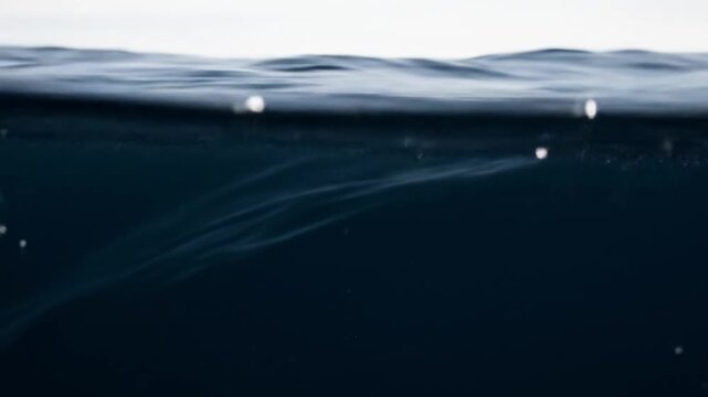 Captivating Ocean Surface: Dark Blue Sea Water with Gentle Waves and Sparkling Highlights