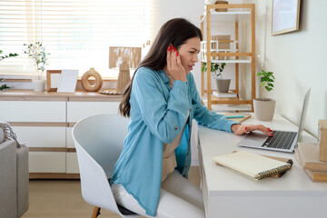 Young woman with otitis feeling pain in ear while using laptop at home