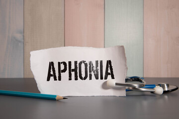 Paper with text APHONIA on table with stethoscope.