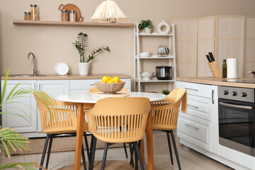 Interior of kitchen with dining table, counters and shelf unit