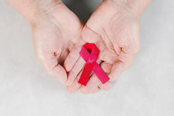 One red measuring tape in the palms of a woman.