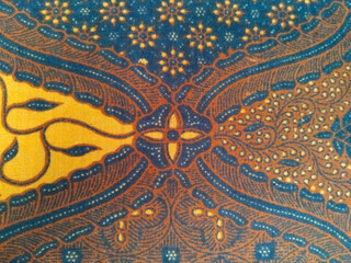 Traditional batik fabric with intricate brown, blue, and yellow patterns, featuring floral and...