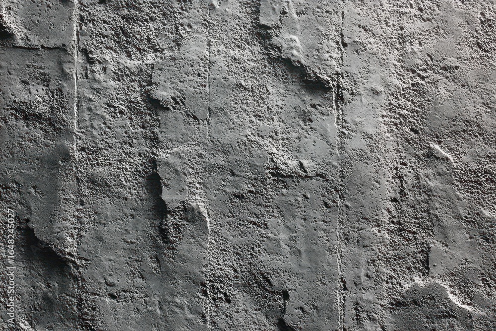 Poster close-up view of a rough and textured dark concrete wall surface with uneven patches and visible ver