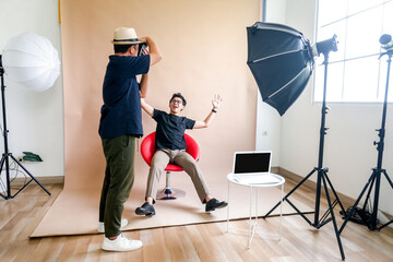 Photographer Captures Seated Model During Creative Studio Shoot