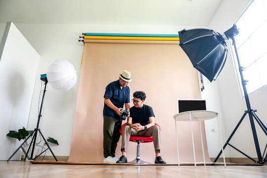 Photographer Shows Result To Model During Studio Portrait Session