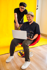 Photographer And Model Share A laugh While Reviewing Photos On A Laptop During A Fun Studio Session