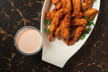 Fried chicken strips on a plate with sauces ...
