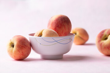 Fresh peaches in a bowl on pink background, Summer fruit