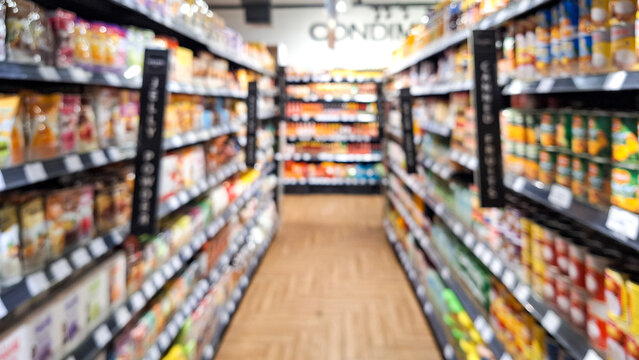 Defocused photo of A supermarket store aisle with a variety of products on the shelves. abstract blur of convenience store aisle, fast moving consumer goods industry urban lifestyle concept.