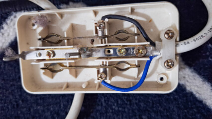 Internal wiring of a multiplug extension cord, revealing a potentially hazardous setup. broken electrical socket.