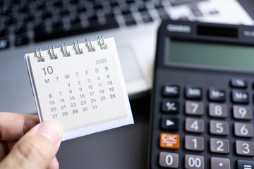 Desk Calendar with Calculator and Laptop for Business Planning in OCTOBER 2025. calendar OCT 2025....