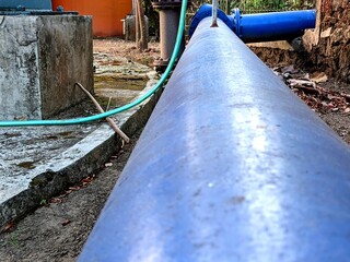 Blue Water Pipe and Green Hose Infrastructure Outdoors Industrial Environment