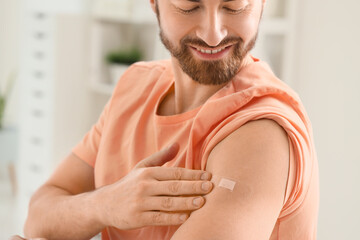 Young man with applied medical patch after vaccination in clinic, closeup