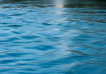 Gently rippling blue water surface reflecting light, showcasing subtle wave patterns and textures.