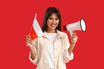 Young woman with flag of Poland and megaphone on red background