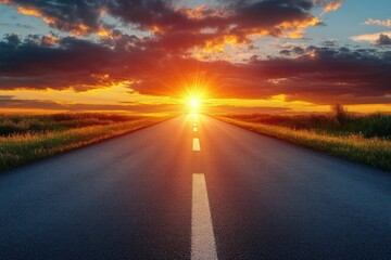 Long empty road leading towards a vibrant sunset with radiant sun and dramatic clouds over open fields on both sides