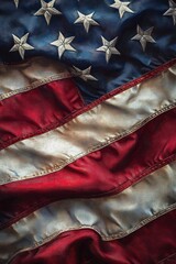 Close-up of a textured, wrinkled flag with white stars on a blue field and red and white stripes showing wear and folds