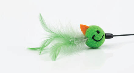 Green smiling bird cat toy with feathers on white background