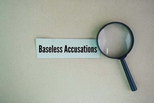 Magnifying glass and paper with the words baseless accusations. A false accusation is a claim or allegation of wrongdoing that is untrue and/or otherwise not supported by facts.
