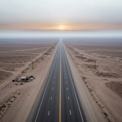 Fototapeta premium Desert highway stretching toward the horizon under a hazy, pastel colored sky