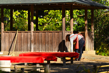 茶屋の落葉を掃く女性