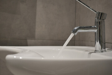 Modern sink with running water in a bathroom setting