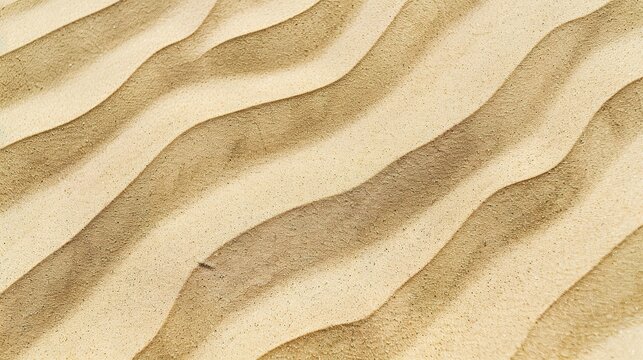 Windblown sand texture with smooth parallel ridges in light brown natural desert patterns showing erosion and geological formation details under sunlight.