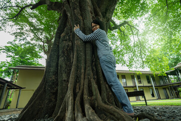 Asian woman hugging big tree trunk. Eco retreat. Nature connection therapy for mental health...