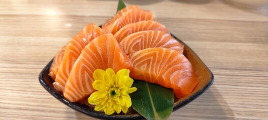 8 pieces of salmon on a black triangular tray