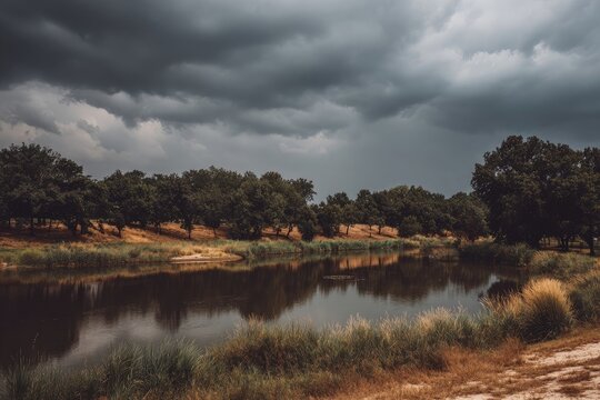 Calm pond reflecting stormy sky, trees line the shore