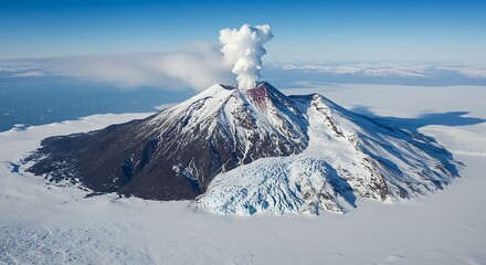Mount Cleveland volcano in the Aleutian Islands with rising steam and snow covered landscape surrounded by cold waters and a clear blue sky