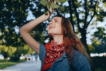 Lifestyle woman in modern boho-western denim street style smiling outdoors with film color effect...